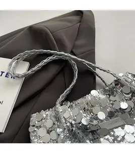 Close-up of silver sequin tote bag with metallic texture and woven shoulder strap