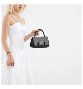 Close-up of black and grey contrast handbag with golden M logo and pebble leather texture