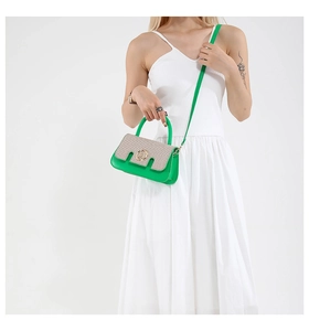 Detail of green leather and beige woven straw texture on a chic mini crossbody bag