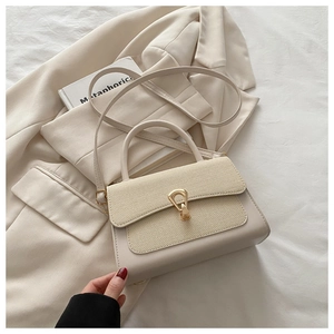 Detail of a beige handbag featuring woven texture and gold waterdrop metal buckle