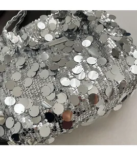 Detailed view of silver sequin tote bag with metallic shine and fashion brand label