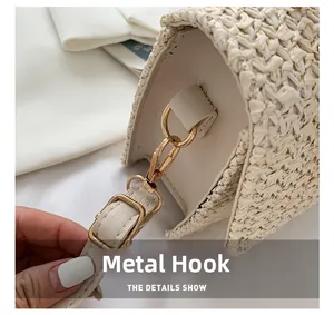 Detail view of gold hardware hook and strap on woven beige crossbody handbag