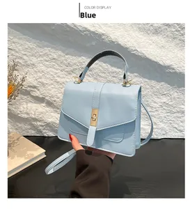 Detalle de bolso bandolera azul claro con cierre de metal dorado y textura suave