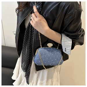 Close-up of blue denim texture bag with gold metal frame and sparkling crystal clasp