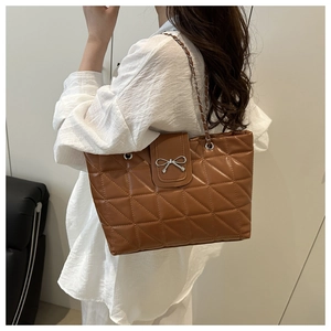 Détail du sac cabas matelassé marron avec boucle nœud argentée et bandoulière chaîne