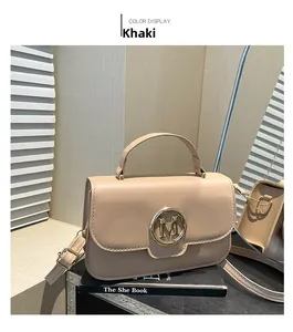 Detail view of khaki PU leather handbag with gold M letter ring buckle on decorative books