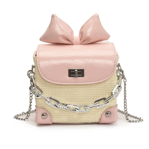 Pink and beige woven crossbody bag with a large bow and decorative chunky chain strap