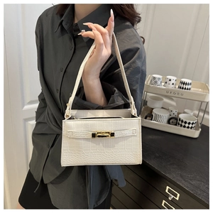 Detail of white crocodile pattern shoulder bag featuring golden metallic buckle closure