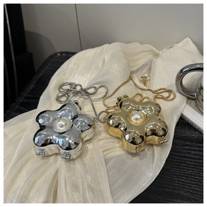 Detailansicht der gold- und silberfarbenen Blumen-Clutches mit Perle und Metallkette