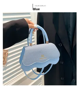 Close-up of light blue handbag with wavy flap and woven texture detail