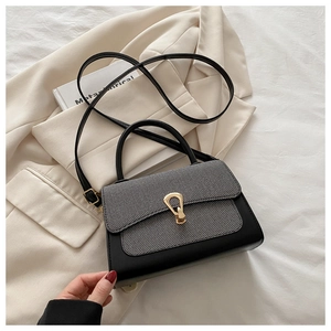 Detail of grey fabric and black leather contrast handbag with gold horseshoe buckle