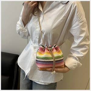 Détail d'un sac seau tissé arc-en-ciel avec chaîne dorée et cordon orné de perles