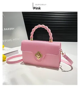 Detail of pink leather handbag with knit flap, braid handle and gold flower twist lock