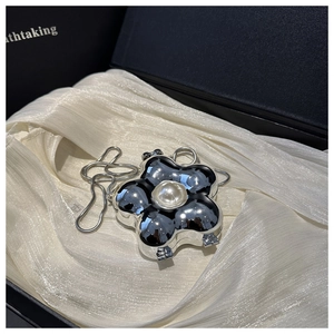 Detailansicht der silbernen Blumen-Clutch mit Perle und Kette in hochwertiger Geschenkbox