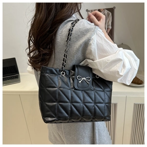 Détail du sac bandoulière noir matelassé avec boucle nœud argenté et chaîne