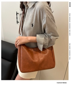 Detail of brown soft leather tote showing vertical stitching and vintage fine texture