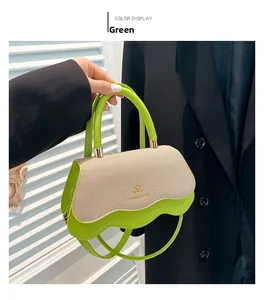 Detail of green leather crossbody bag featuring beige woven flap and gold brand logo