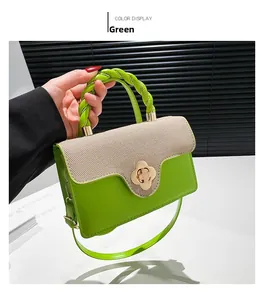 Detail of green leather and beige woven handbag with floral buckle and braided handle