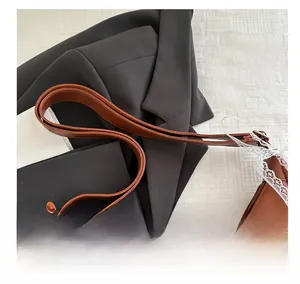Detail shot of brown crescent underarm bag featuring delicate white lace trim and zipper