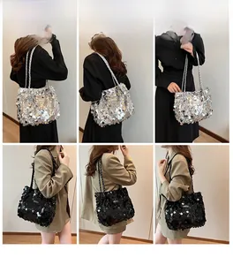 Detail of a shiny sequined tote bag with woven shoulder straps in black and silver