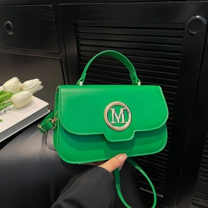 Vibrant green crossbody bag with golden M letter logo and detachable shoulder strap