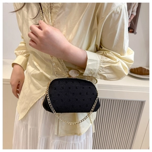 Detail of vintage black polka dot evening bag with rhinestone lock and gold chain
