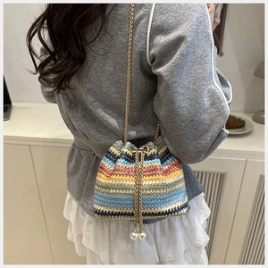 Détail du sac seau au crochet coloré avec tissage rayé et perles sur le cordon