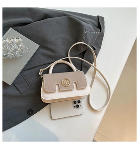 Detail of beige contrast handbag with brown woven flap and golden M logo hardware