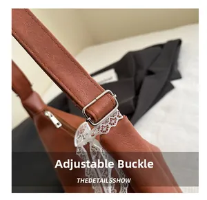 Detail shot of the silver adjustment buckle and white lace trim on a brown leather strap