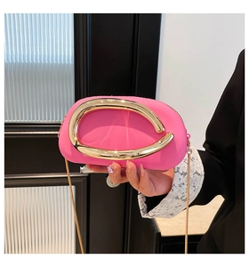 Detail der pinkfarbenen Clutch mit goldener C-Schnalle und elegantem Kettenriemen