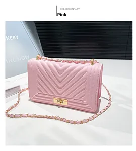 Detail of pink quilted leather shoulder bag with golden lock and chain strap