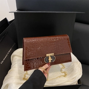 Brown crocodile-textured handbag with gold and black metal clasp and chain strap
