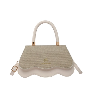 Color-block crossbody bag with wave edges and gold logo hardware in a minimalist style