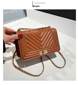 Close-up of brown soft leather shoulder bag with chevron quilting and golden metal lock