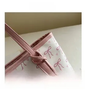 Macro shot of pink bow print on tote bag with reinforced stitching and leather edges