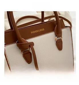 Close-up of contrast color tote bag showing fine litchi texture and gold hardware details