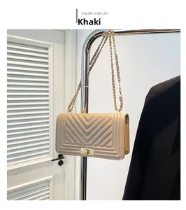 Close-up of khaki chevron quilted leather shoulder bag with golden metal chain strap