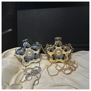 Nahaufnahme sternförmiger Metall-Abendtaschen in Silber und Gold mit Perlenbesatz