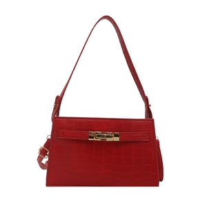 Red crocodile texture handbag with gold twist lock and shoulder strap on white backdrop