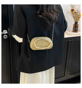Detail of champagne gold evening clutch with large metal buckle and chain strap