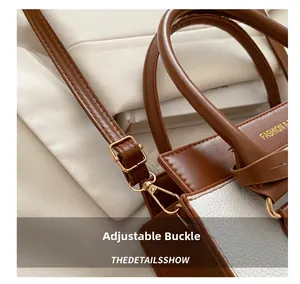 Detail of retro brown and white crossbody bag with gold hardware and adjustable strap