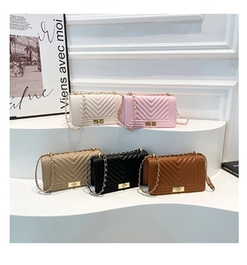 Multiple colors of quilted leather chain shoulder bags displayed on white pedestals