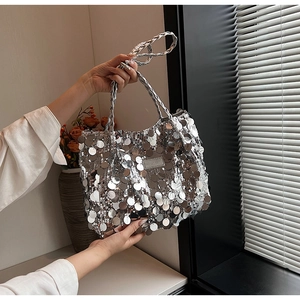 Close-up of silver sequin tote bag featuring metallic fish scale texture and woven handle