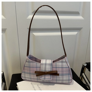 Detail of checkered baguette bag with bow accent and slim brown shoulder strap