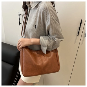 Detail showing brown faux leather tote with fine pebbled texture and dual stitching