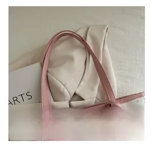 Close-up of the pink leather shoulder strap and fine stitching on a bow print tote bag
