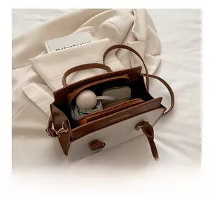 Internal view showing large capacity and compartments of the contrast color handbag
