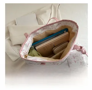 Spacious interior of white tote bag with pink bows and matching zipper coin purse