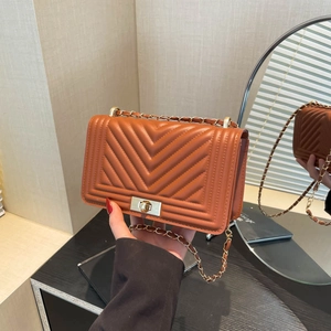 Quilted caramel leather crossbody bag with metal chain strap and turn-lock closure