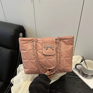 Pink quilted tote bag with silver bow accent and metal chain straps for women